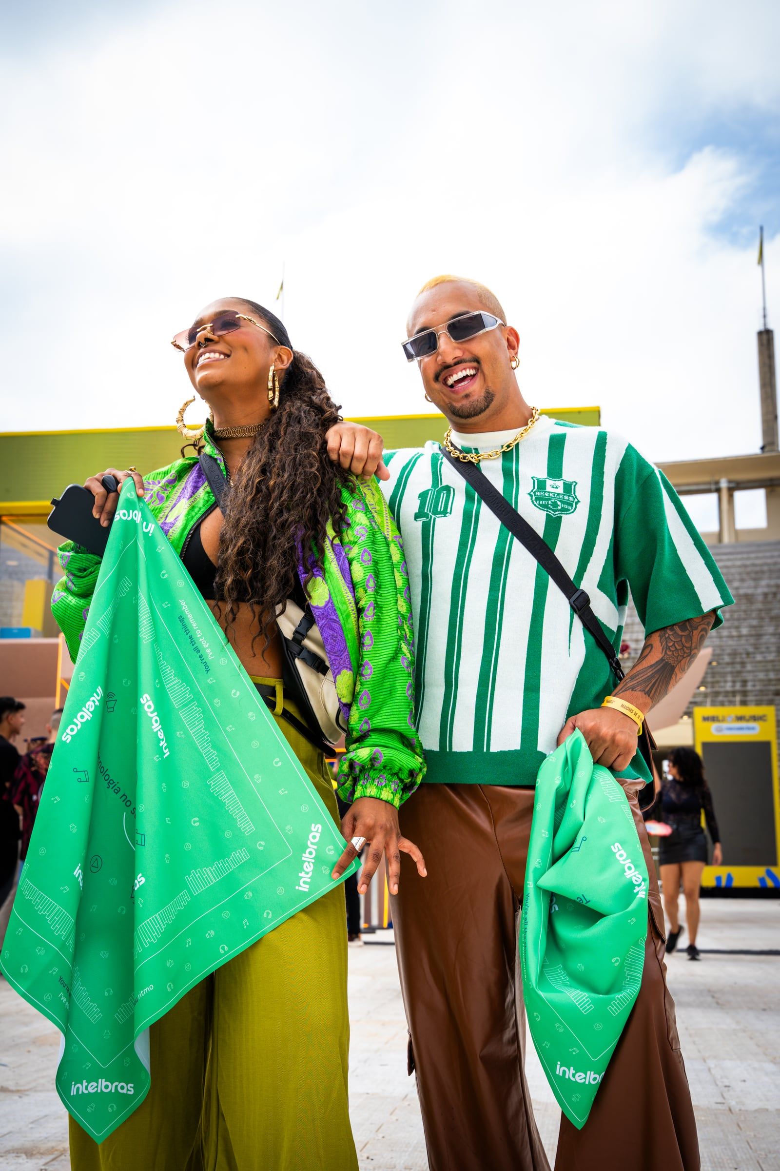 Casal com roupas verdes e bandanas da Intelbras no estádio